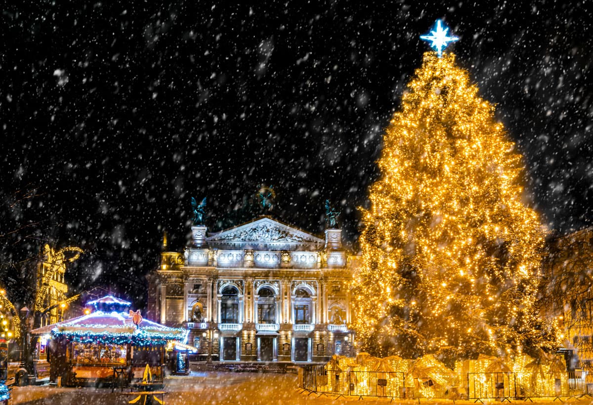 Sapin de Noël illuminé devant l'Opéra de Lviv sous la neige